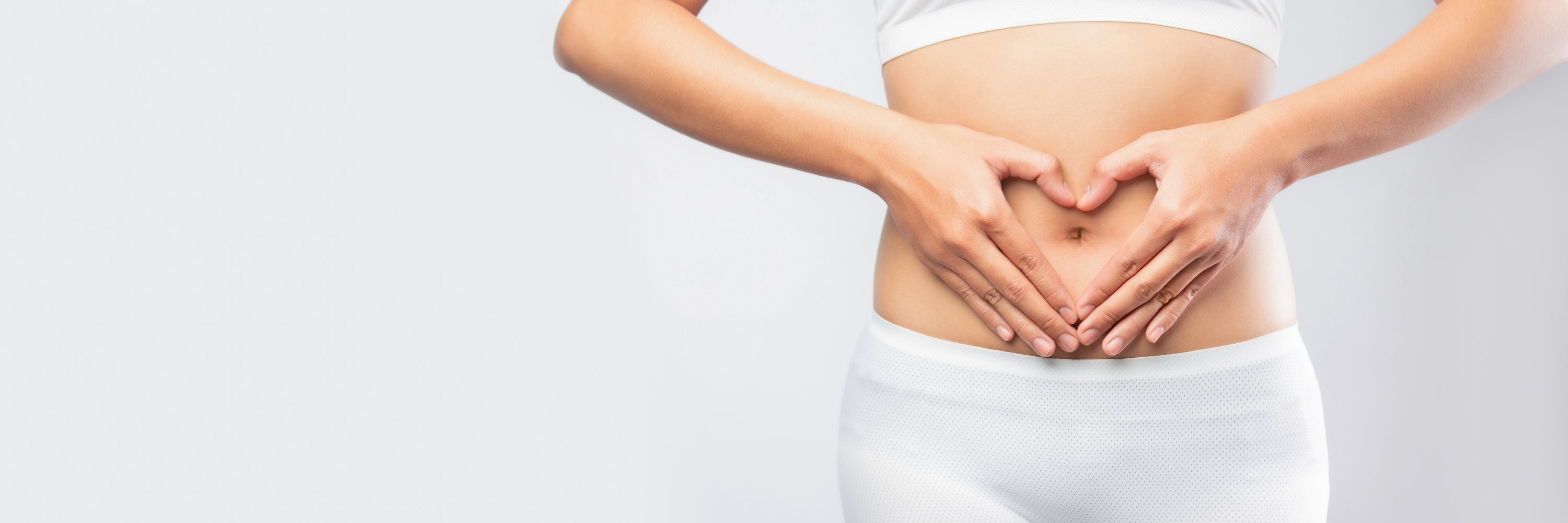 Woman holding hands in heart shape over stomach. Gut Health Supplements, headley holistics