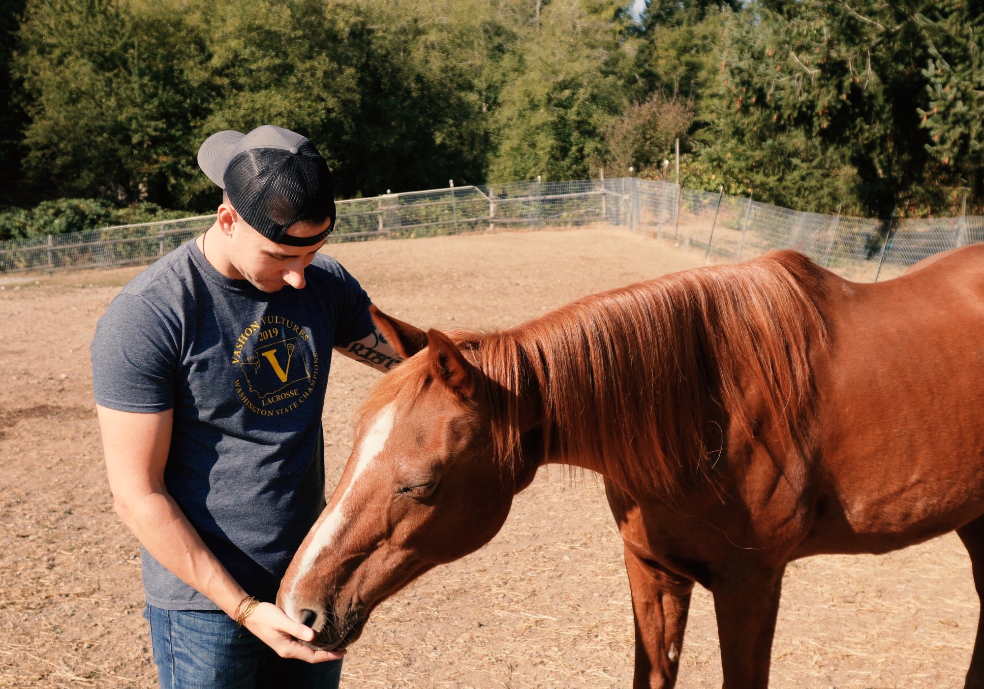 Headley Holistics and Evolved Remedies Founder, Tristan, embracing one of their rescued horses, ranger, in a sweet and tender moment